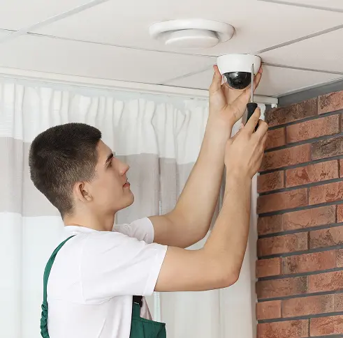 Technician installing a ceiling camera